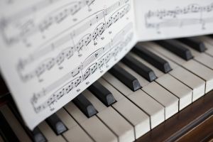 Close up sheet music over piano keys
